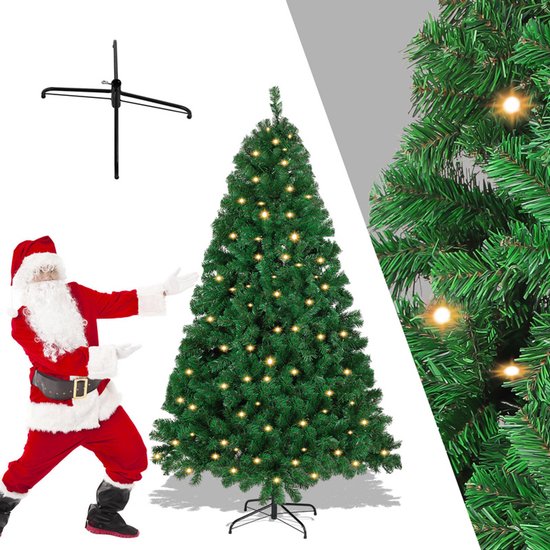 Groene kunstkerstboom met 150 warmwitte ledlampjes, staand op een kruisvoet. Kerstman wijst naar de boom.