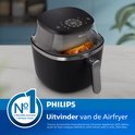 Zwarte Philips Airfryer met kijkvenster, met een goudbruin gebraden kip zichtbaar. Links de 'Nr 1 Werelds nummer 1 Airfryer merk' badge.