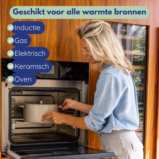 Vrolijke vrouw met blond haar in spijkerblouse zet een pan in een open oven.