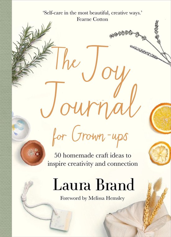 Boek 'The Joy Journal for Grown-ups' met afbeeldingen van gedroogde sinaasappels, lavendel en een stuk zeep.
