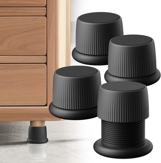 Vier zwarte meubelhoogteverstellers met ribbels en een ronde antislipmat, naast een houten meubel.