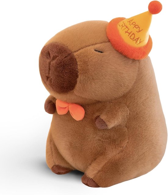 Peluche capybara marron avec nœud papillon orange et chapeau de fête jaune 'Happy Birthday'.
