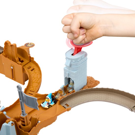 Hand lanceert een blauwe en witte Kamek-auto met een rode trekker op de Hot Wheels Mario Kart Bowser's Castle Raceway.