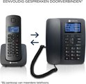 Zwarte Motorola C4201 draadloze telefoon met lader en bedrade telefoon, met pijlen die connectiviteit tonen.