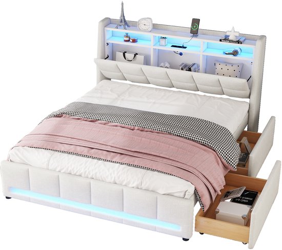 Wit gestoffeerd bed met open lades en opbergvakken in het hoofdbord met blauwe LED-verlichting. Bed is opgemaakt met wit beddengoed, roze plaid en zwart-wit geblokte plaid.