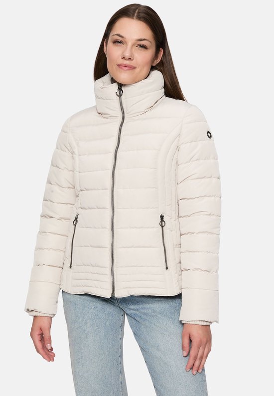 Model draagt crème gewatteerde jas Ronja2 met hoge kraag, spijkerbroek.