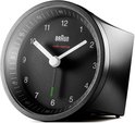 Zwarte Braun wekker met analoge wijzerplaat, witte wijzers en groene secondewijzer, van opzij gezien.
