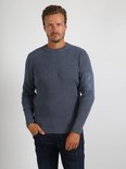 Man met donkerblauw gemêleerde trui met ronde hals, verticale ribbels en een opgestikte zak met ritssluiting op de linker mouw.