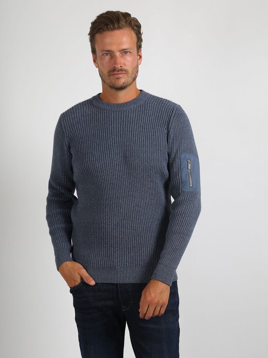Man met donkerblauw gemêleerde trui met ronde hals, verticale ribbels en een opgestikte zak met ritssluiting op de linker mouw.