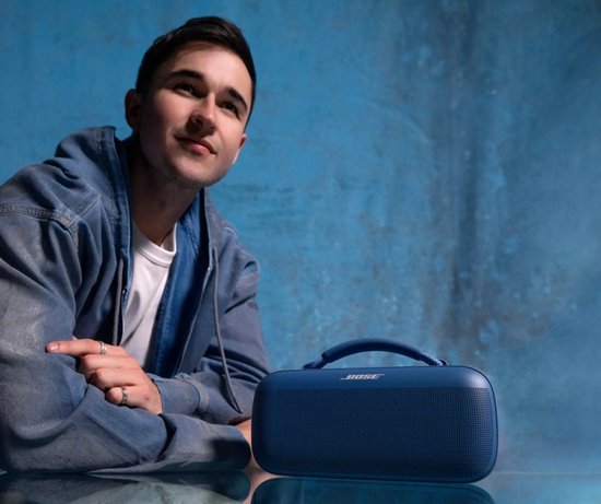 Man naast een blauwe Bose SoundLink Max Bluetooth speaker.