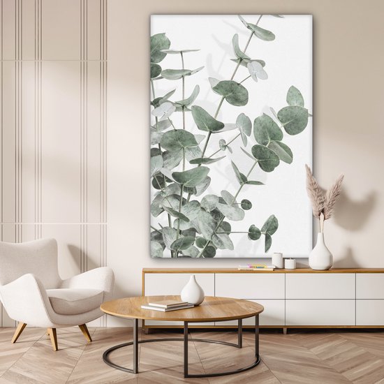 Canvas van eucalyptusbladeren in een lichte woonkamer boven een dressoir.