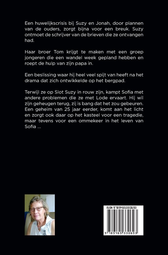 Een vrouw met kort, grijs haar en bril kijkt met een vriendelijke glimlach naar de camera. Ze draagt een witte blouse.