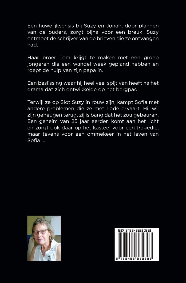 Een vrouw met kort, grijs haar en bril kijkt met een vriendelijke glimlach naar de camera. Ze draagt een witte blouse.
