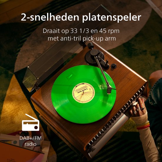 Platenspeler met groene plaat, houten behuizing en een glazen kap. DAB+/FM radio.