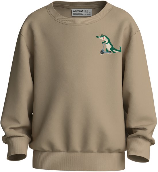Beige trui met op de borst een kleine groene krokodil op een scooter. Het label 'name it' is zichtbaar.