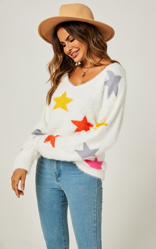 Model draagt witte, pluizige trui met veelkleurige sterrenprint en V-hals. Blauwe jeans en bruine hoed.