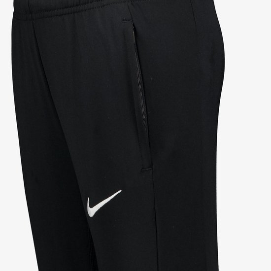 Zijzak met rits en witte Nike swoosh op een zwarte trainingsbroek.