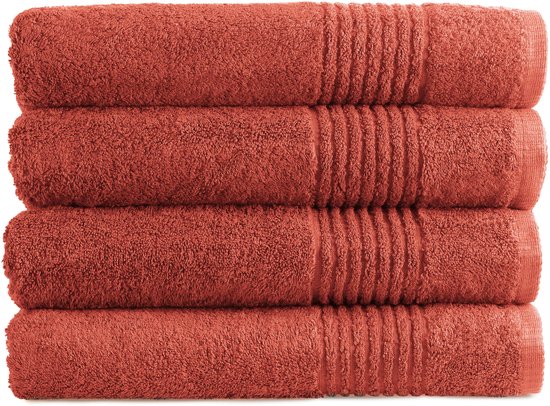Pile de quatre serviettes rouille avec texture côtelée, sur fond blanc.