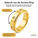 Gouden draaibare ring met vier zirkonia steentjes. Tekst in het Nederlands: "Gebruik van de Anxiety Ring".