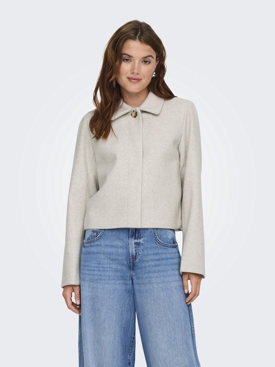 Model draagt een lichtgrijze korte jas van ONLY met jeans.