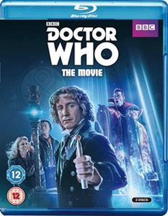 Doctor Who: The Movie Blu-ray hoes. Man in donker pak met een staaf. Drie andere personen zichtbaar. Logo's BBC en 12.