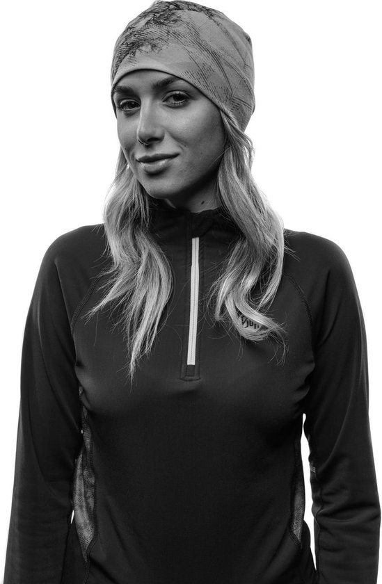 Zwart-wit portret van een vrouw met een muts met patroon en een sportief vest.