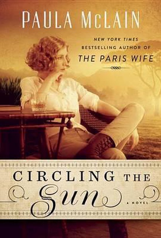 Boek 'Circling the Sun' van Paula McLain. Vrouw zit aan tafel buiten met een glas drank.