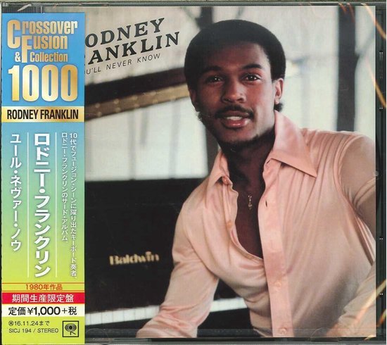 Rodney Franklin met een zalmkleurige blouse en een ketting, zittend voor een piano. Albumtitel "You'll Never Know".