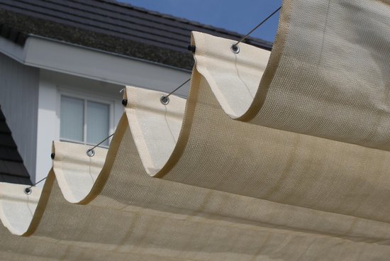 Voile d'ombrage ivoire en accordéon avec œillets métalliques et vue sur une maison