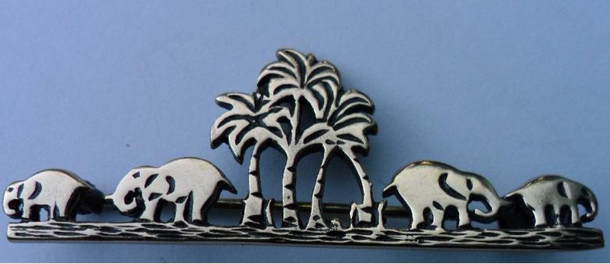 Een Zilver broche met de afbeelding van vier olifanten met vier palmbomen in het midden