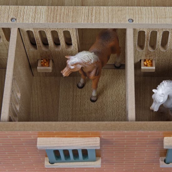 Houten paardenstal interieur met paarden in de boxen, houten schuttingen en voerbakjes.