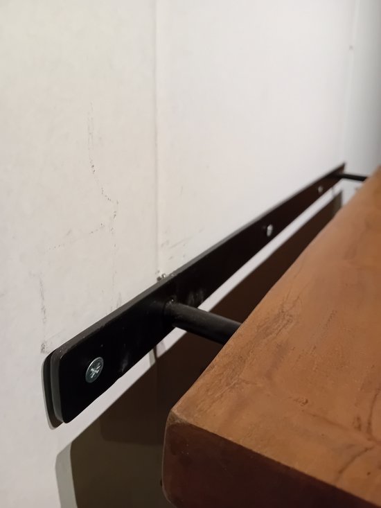 Close-up van de zwarte metalen plankdrager onder een houten plank, vastgezet met schroeven.