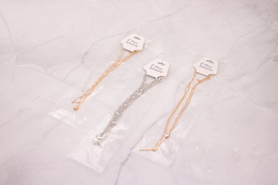 Drie Pax Amare kettinkjes in verpakking: goudkleurig met parels, zilverkleurig met sterretje en goudkleurig met staafje.