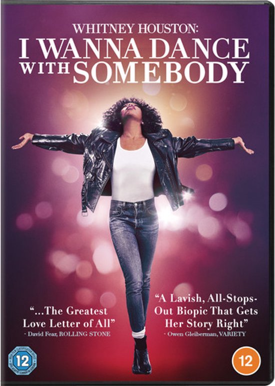 Whitney Houston in "I Wanna Dance with Somebody". Ze draagt een witte top, jeans en leren jack. Ze heeft haar armen wijd gespreid.