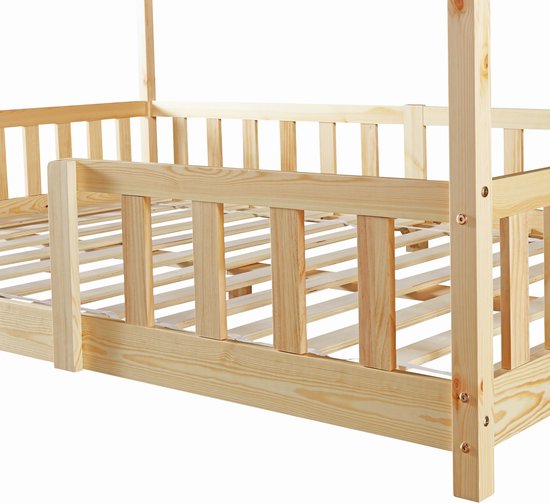 Détail des barreaux en bois et de la construction d'un lit maison naturel.