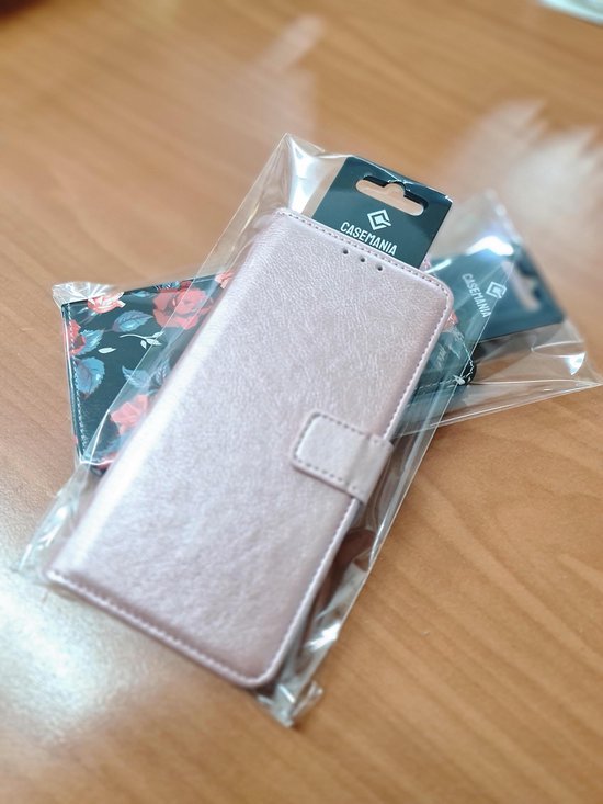 Coque portefeuille rose pour téléphone avec imprimé floral, emballée.