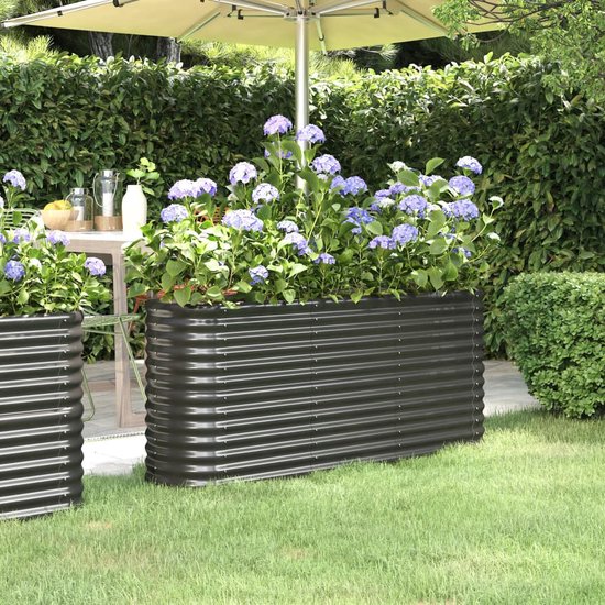 Antracietkleurige stalen plantenbak met planten in een tuin.