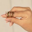 Drie gouden ringen, één met roze steentjes, één met zwarte steentjes en één met gekleurde steentjes.