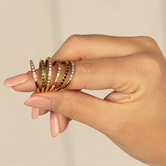 Drie gouden ringen, één met roze steentjes, één met zwarte steentjes en één met gekleurde steentjes.