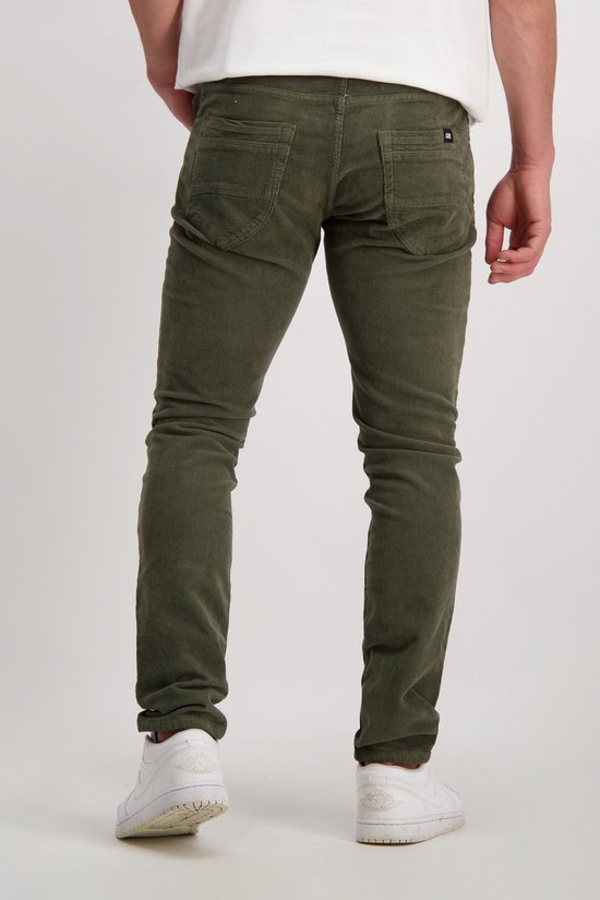 Een man draagt een groene corduroy broek, achterkant.