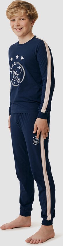 Jongen in donkerblauwe Ajax pyjama met roze strepen langs de zijkant van de broekspijpen en mouwen. Ajax logo op borst en broek.