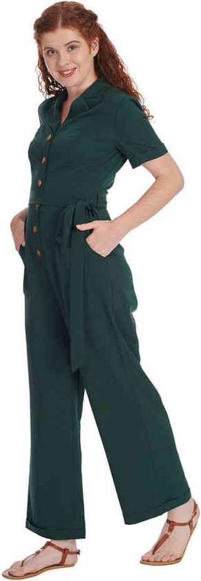 Combinaison vert foncé à manches courtes, col revers et ceinture à nouer. Mannequin les mains dans les poches.