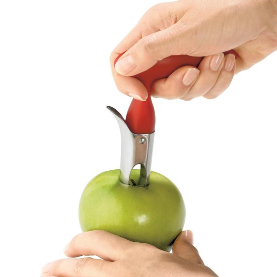 Rode appelboor met zilveren steel, in gebruik bij het verwijderen van het klokhuis van een groene appel.