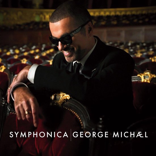 George Michael in zwart pak, zonnebril, zittend in een rode theaterstoel. "SYMPHONICA | GEORGE MICHÆL"