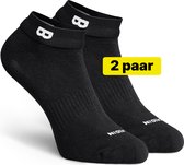 Twee zwarte enkelsokken met witte logo's, tegen een witte achtergrond. Een gele sticker met "2 paar" is zichtbaar.