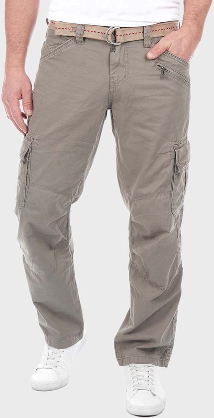 Man draagt grijze cargo broek van Timezone met beige riem, witte sneakers en ritszakken.