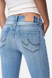 Detail van de achterkant van een lichtblauwe jeans met geborduurde zakken en een bruin label.