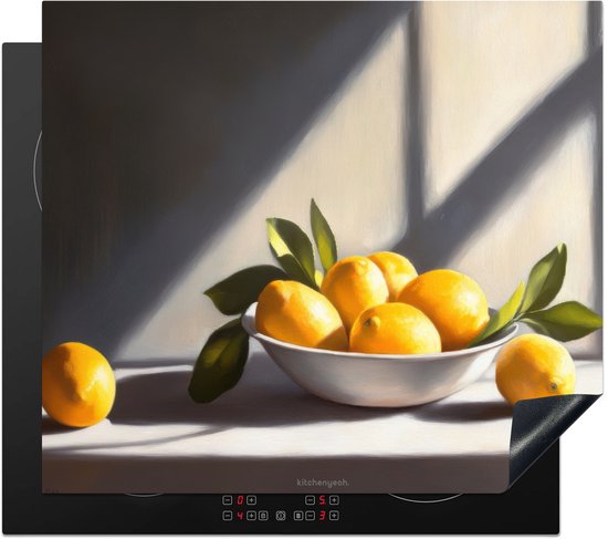Inductiebeschermer met een schilderij van citroenen in een schaal, geplaatst op een inductiekookplaat.