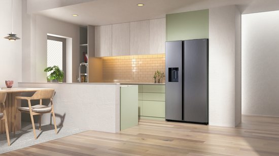 Zilverkleurige Amerikaanse Samsung koelkast met waterdispenser in een lichte, moderne keuken met houten meubels.