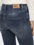 Detail van de achterkant van een blauwe jeans met een bruin leren label met het ONLY-logo.